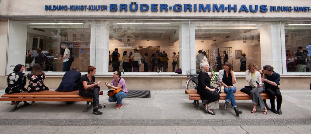 People sitting on benches in front of a building