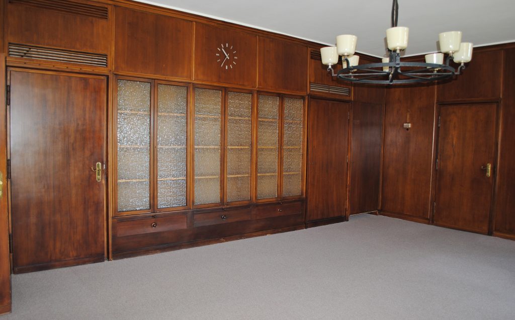 Holzgetäfeltes Zimmer mit unrenoviertem Fußboden