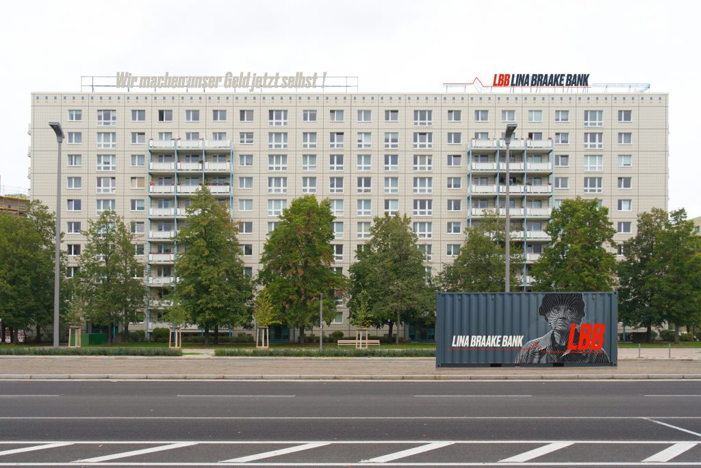 Building with container in front of it, on it a picture of a woman and