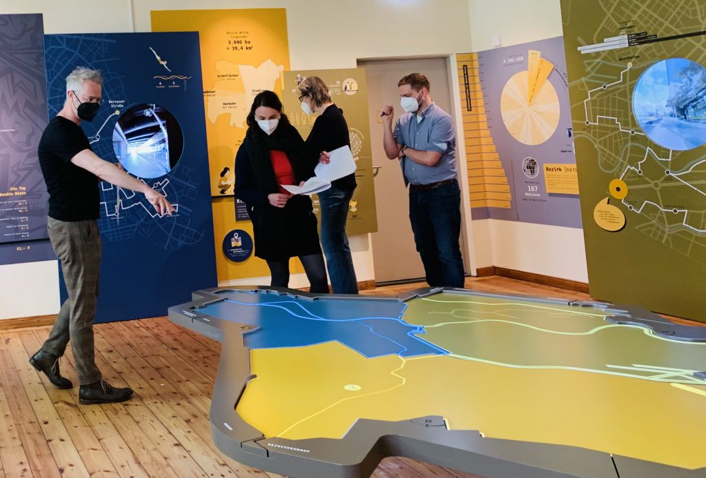 People standing around a stylised map on the floor