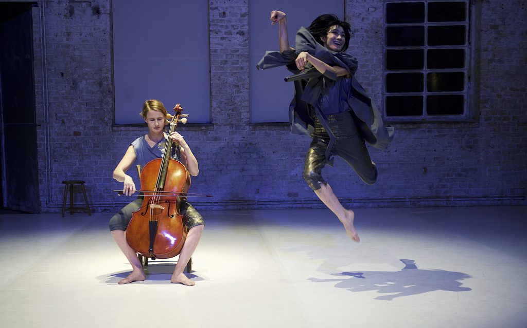 One person plays the cello, another jumps into the air