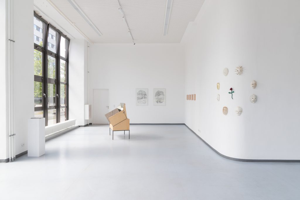 Großer weißer Raum mit Fenster auf der linken Seite und Objekt aus Holz in der Mitte