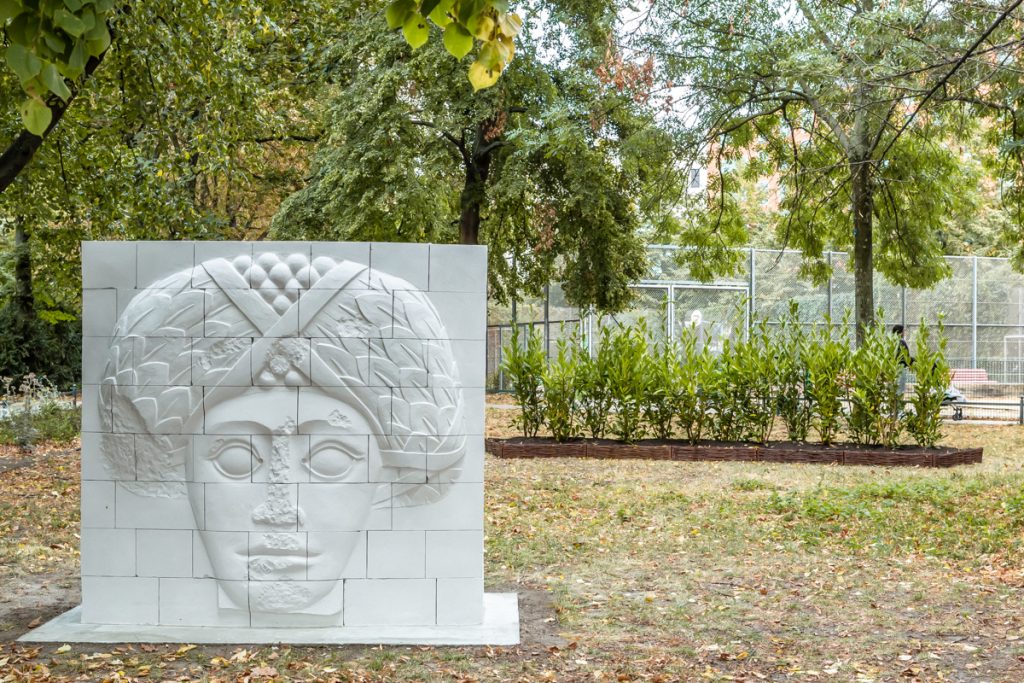 Kleine Mauer mit Gesicht darauf in einem Park