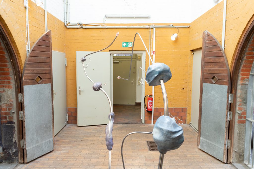 Skulptur aus gebogener Eisenstange und groben grauen Formen im Innenhof des Bärenzwingers