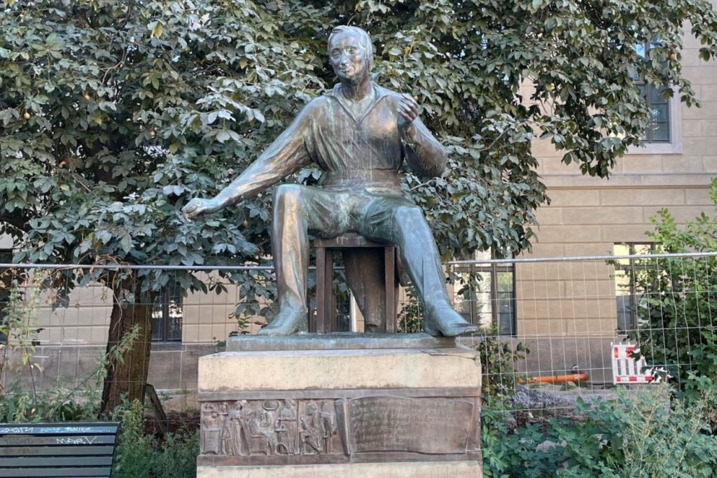 Bronzestatue eines sitzenden Manns