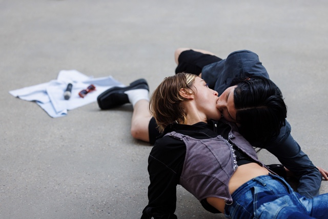 Zwei Menschen sitzen auf dem Boden und küssen sich