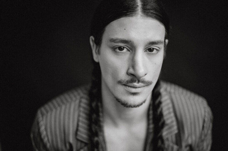 Mensch mit langen Zöpfen und Bart