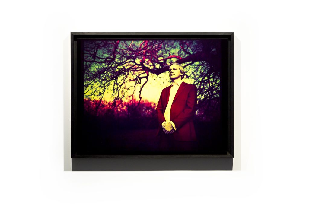 Verfremdetes Foto eines Mannes in dunklem Anzug, der unter einem Baum steht.