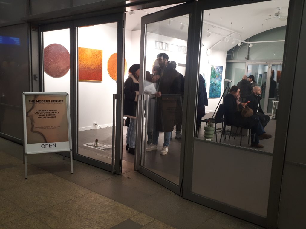 Menschen in einem Ausstellungsraum schauen sich Kunst an