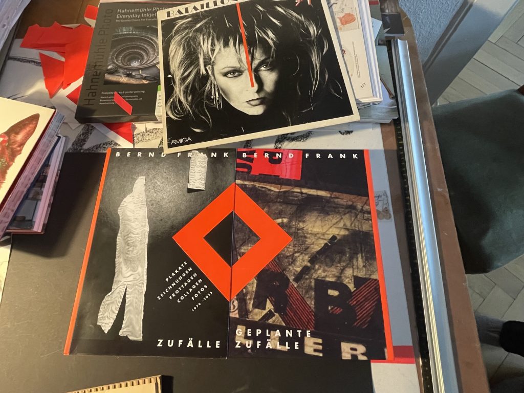 Mit Plakaten und Bildern übersähter Schreibtisch