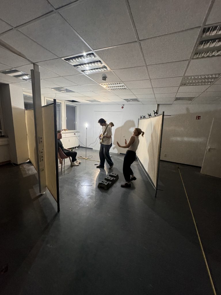 Menschen stehen in einem Raum und sind von Bauzäunen umgeben