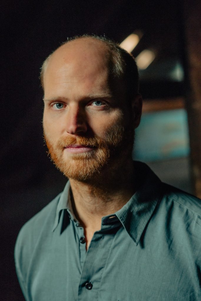 Mann mit Bart schaut in die Kamera